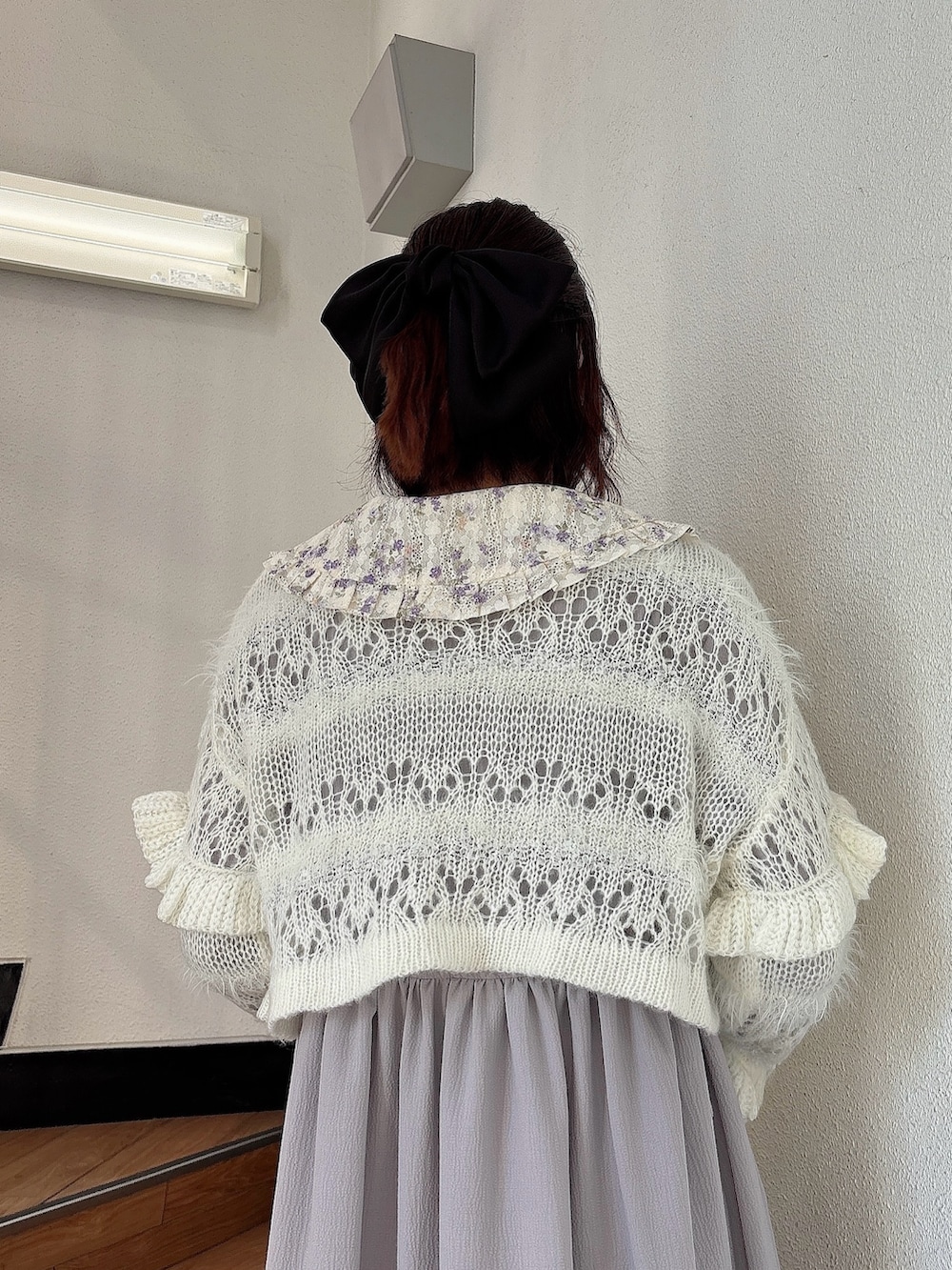ホワイト系のカーディガン/ボレロ、パープル系のワンピース、ブラック系のパンプスを着用したレディースの秋コーディネートの4枚目の写真