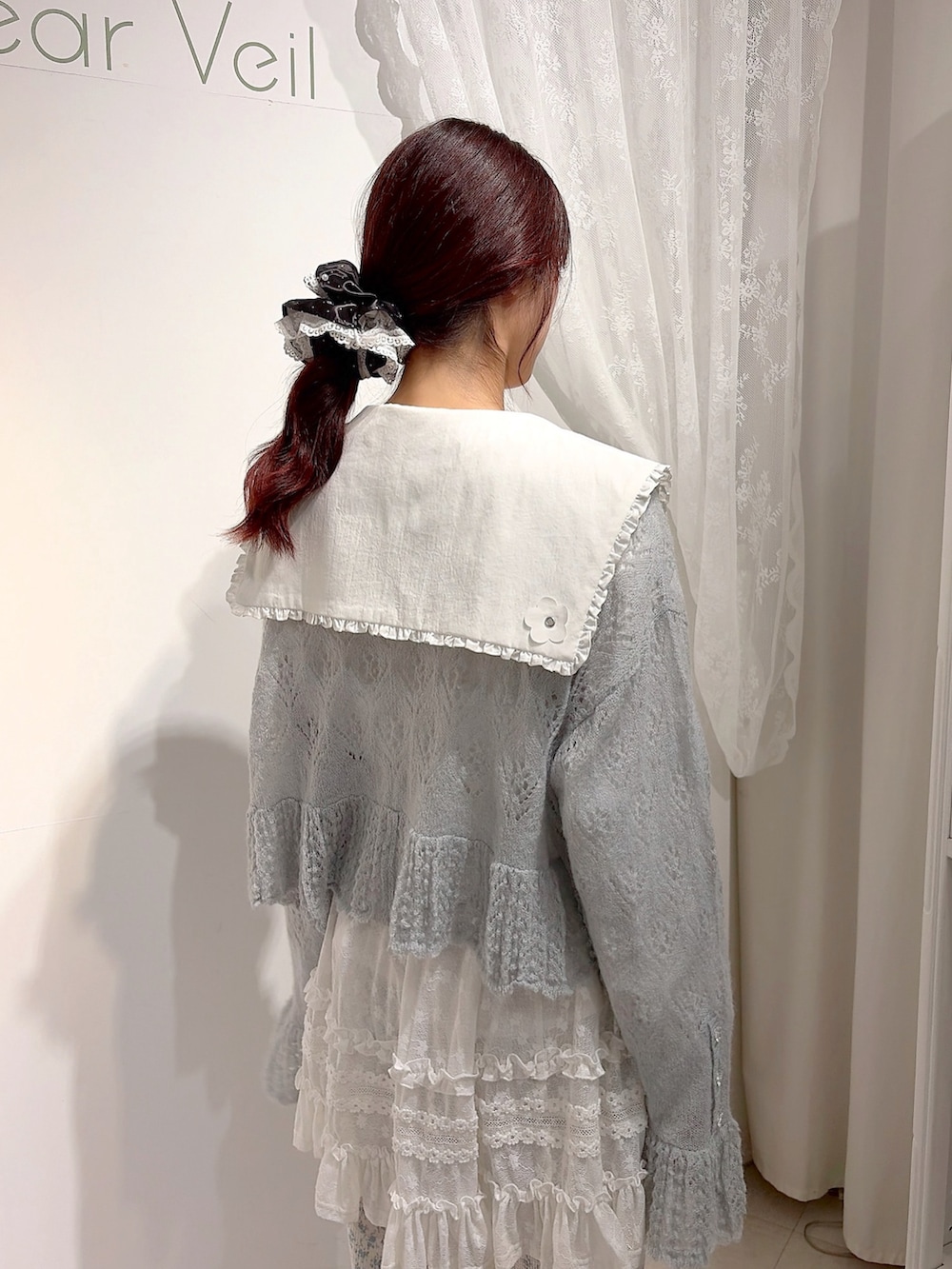 ブルー系のカーディガン/ボレロ、ホワイト系のシャツ/ブラウス、ホワイト系のハンドバッグを着用したレディースの夏コーディネートの5枚目の写真