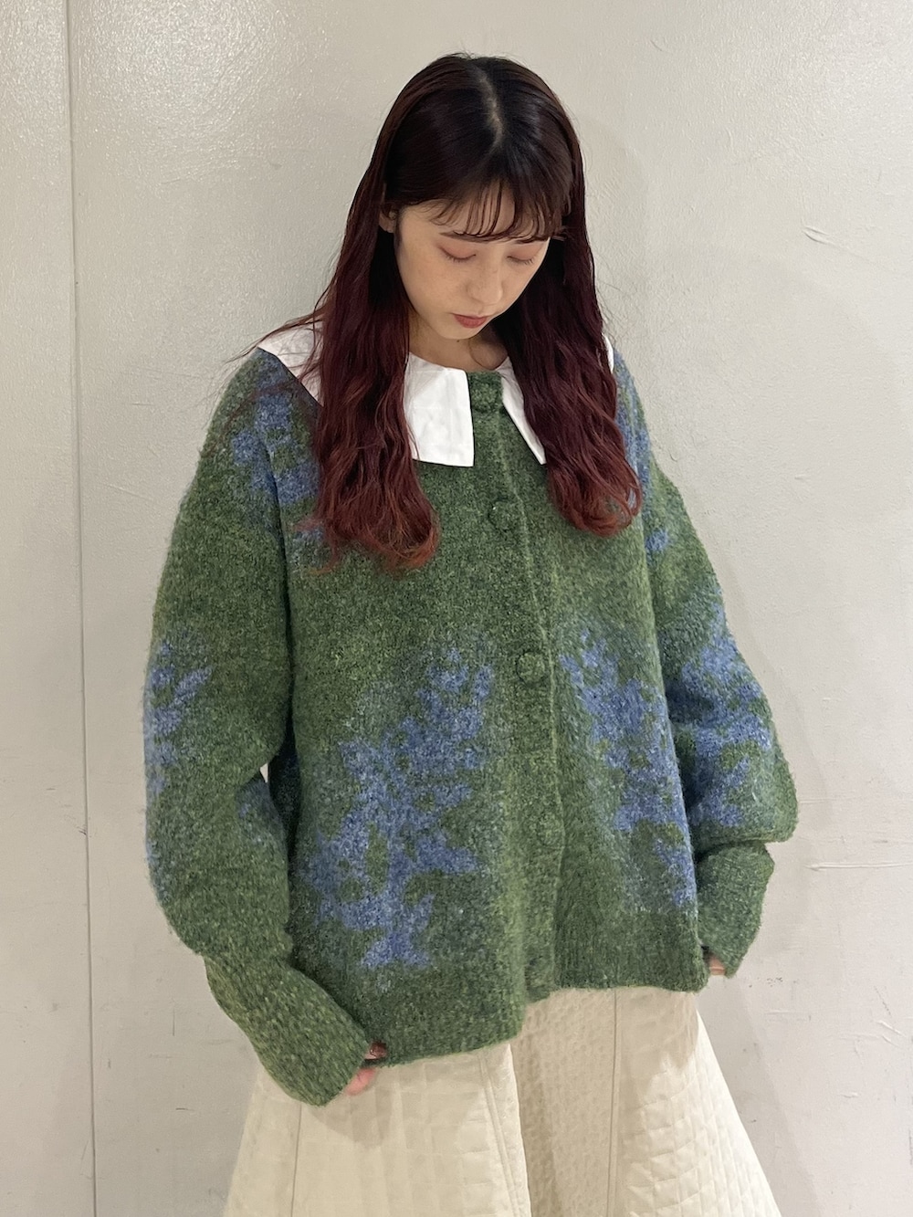 グリーン系のショルダーバッグ、グリーン系のカーディガン/ボレロ、ホワイト系のブーツを着用したレディースの冬コーディネートの2枚目の写真