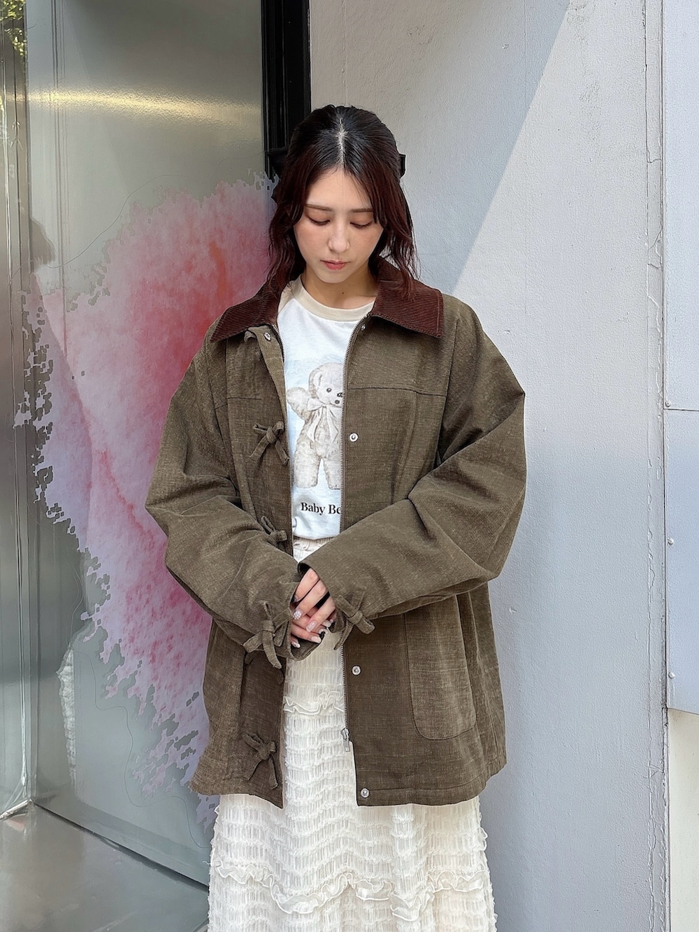 ホワイト系のスカート、ブラウン系のブルゾン、ベージュ系のTシャツ/カットソーを着用したレディースの夏コーディネートの3枚目の写真