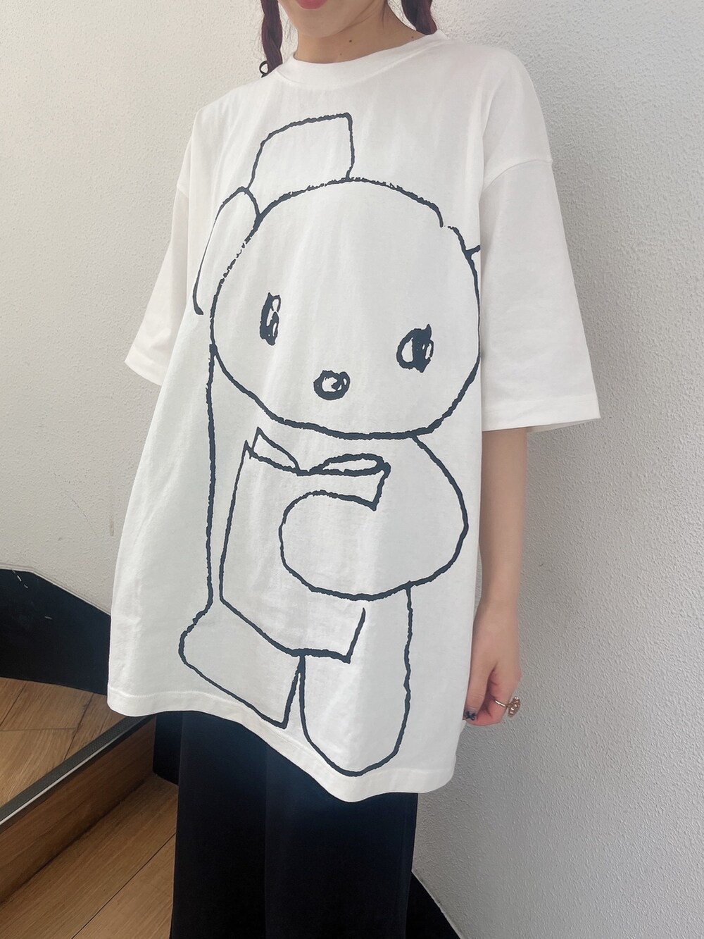 ホワイト系のサンダル、ホワイト系のTシャツ/カットソー、ブラック系のスカートを着用したレディースの春コーディネートの3枚目の写真