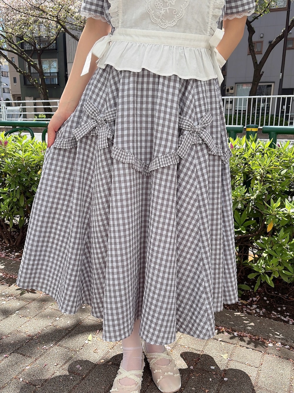 グレー系のシャツ/ブラウス、グレー系のスカート、ホワイト系のシャツ/ブラウスを着用したレディースの春コーディネートの6枚目の写真