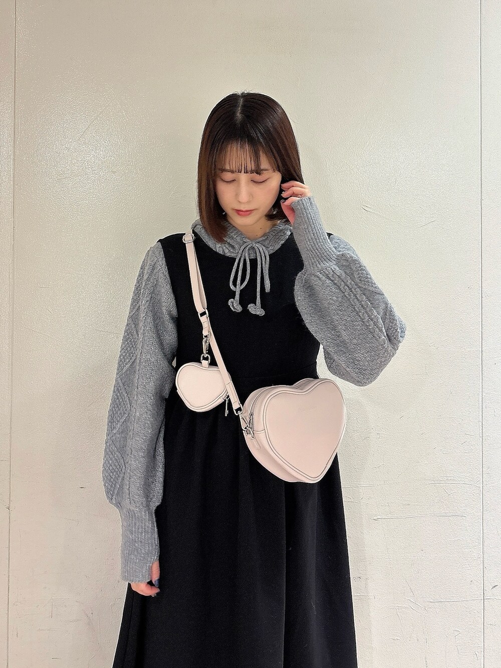 グレー系のニット/セーター、ブラック系のワンピース、ブラック系のブーツを着用したレディースの冬コーディネートの3枚目の写真