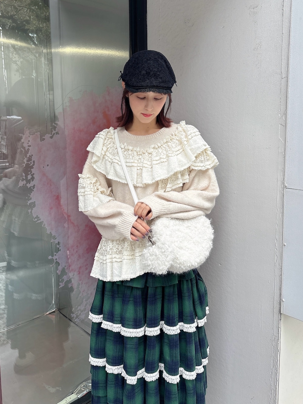 ホワイト系のニット/セーター、ホワイト系のショルダーバッグ、グリーン系のスカートを着用したレディースの秋コーディネートの3枚目の写真