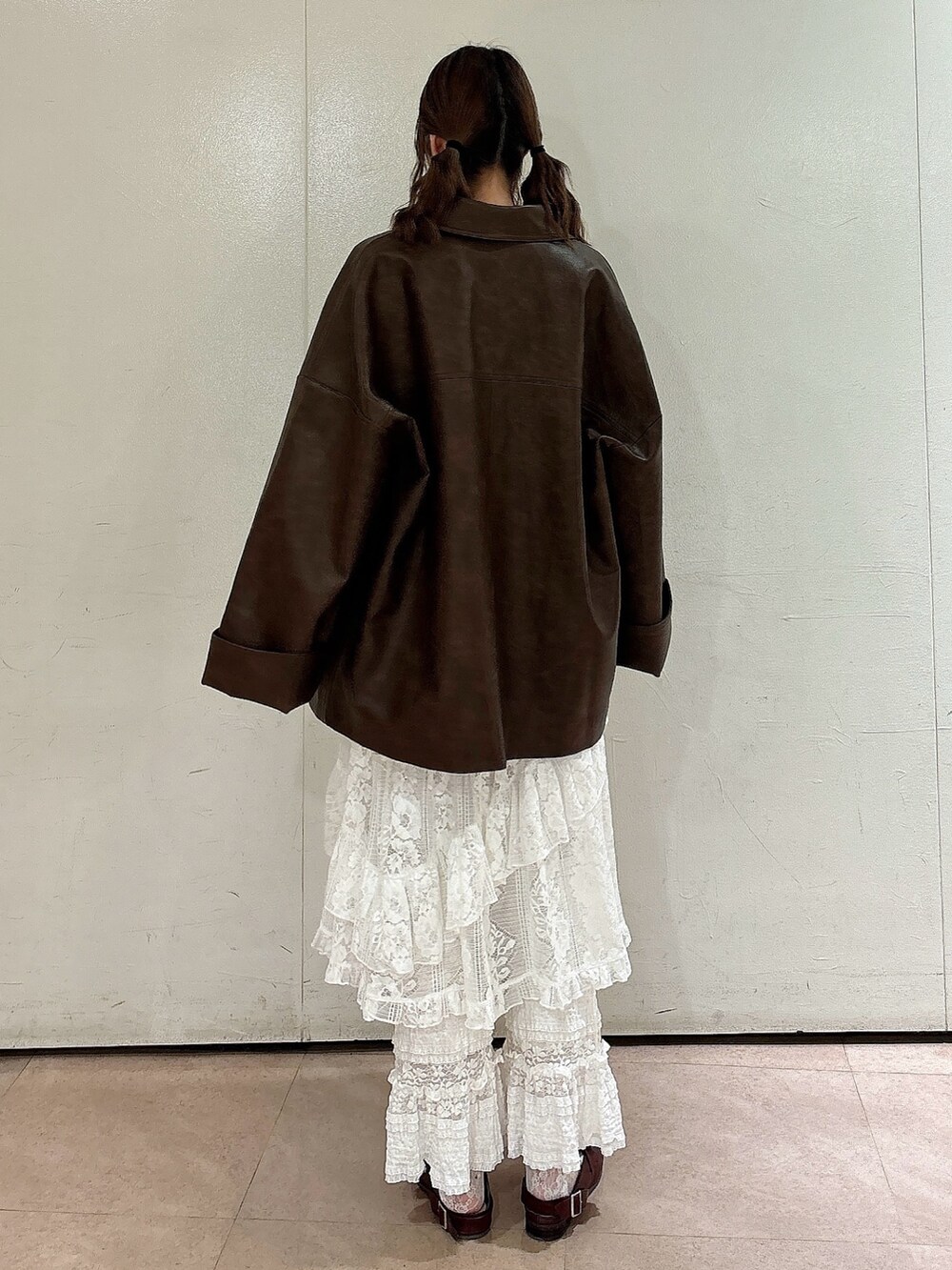 ブラウン系のブルゾン、ブラウン系のニット/セーター、ホワイト系のスカートを着用したレディースの秋コーディネートの2枚目の写真