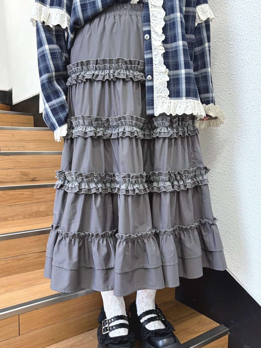 ブルー系のシャツ/ブラウス、グレー系のスカート、ブラック系のスニーカーを着用したレディースの夏コーディネートの6枚目の写真