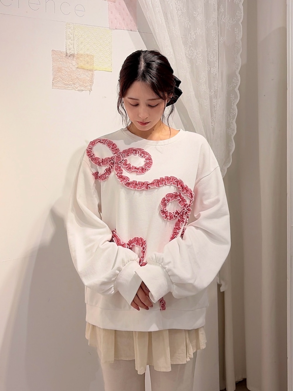 ホワイト系のスウェット、ホワイト系のスウェットパンツ、レッド系のショルダーバッグを着用したレディースの冬コーディネートの3枚目の写真