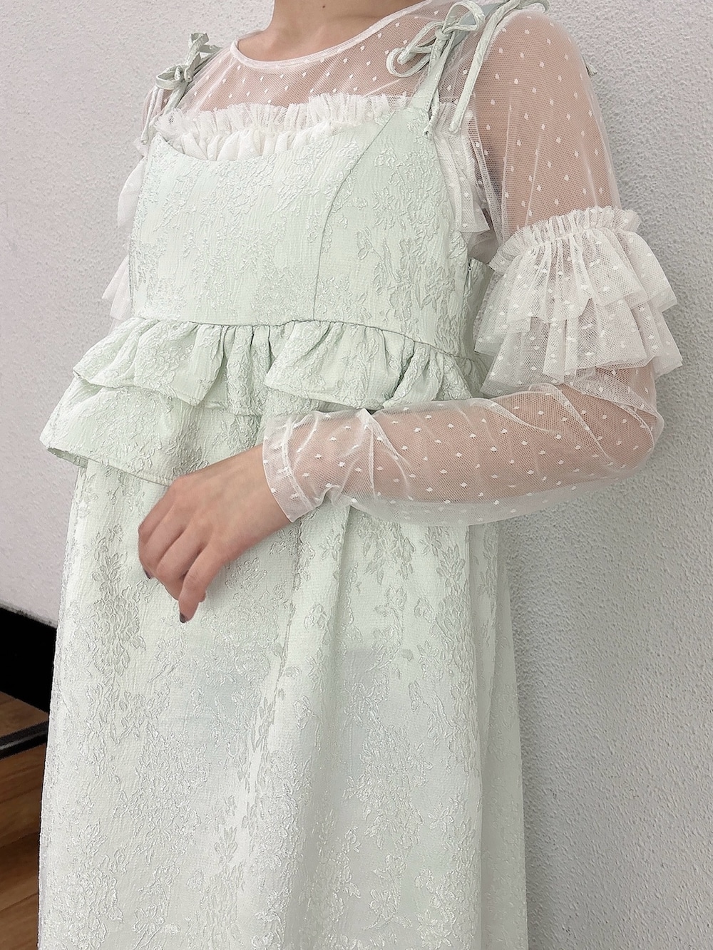 グリーン系のワンピース、ゴールド系のバレエシューズ、ホワイト系のTシャツ/カットソーを着用したレディースの冬コーディネートの3枚目の写真