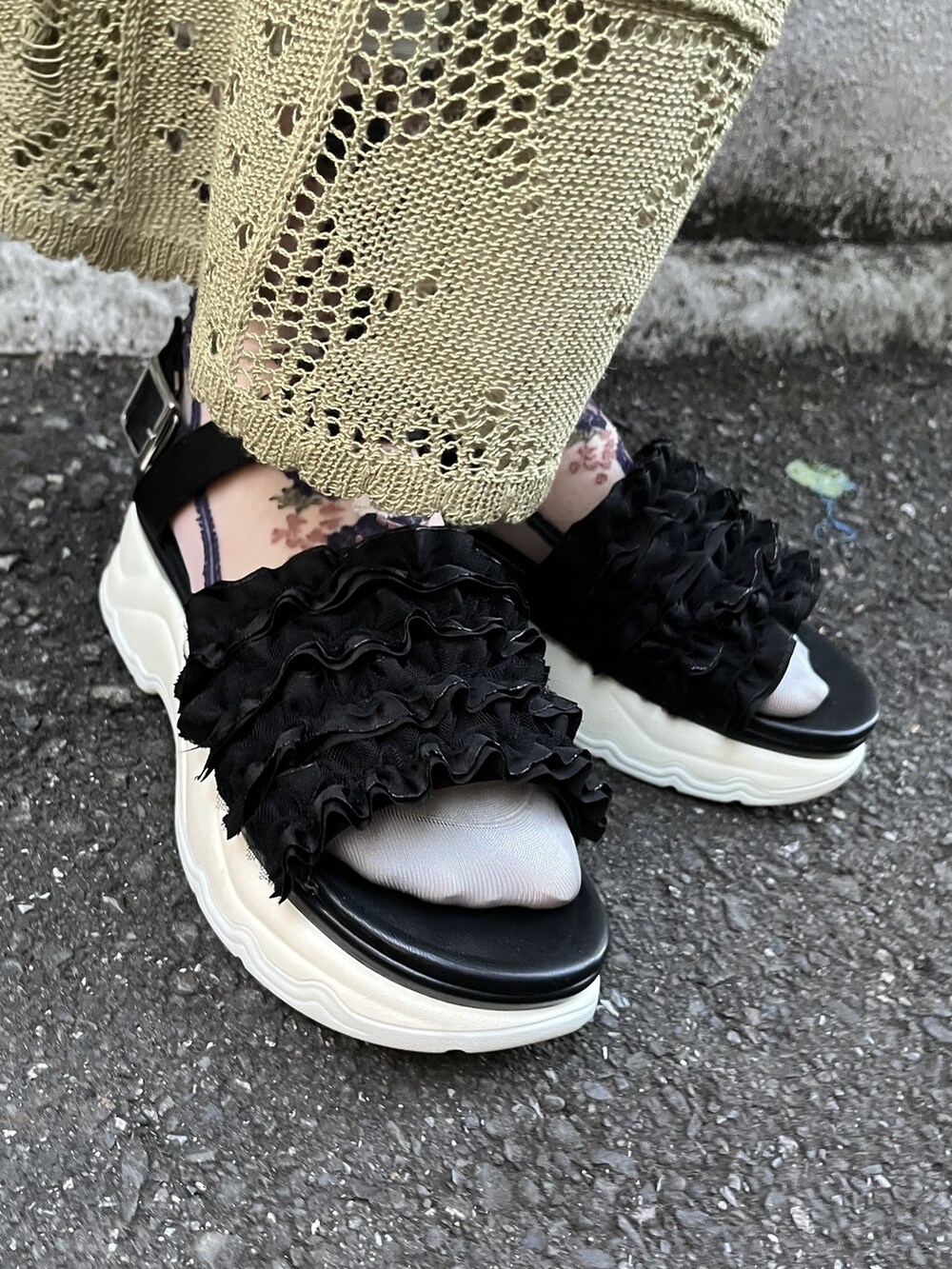 グリーン系のスカート、ブラック系のサンダル、ブラック系のトートバッグを着用したレディースの冬コーディネートの5枚目の写真