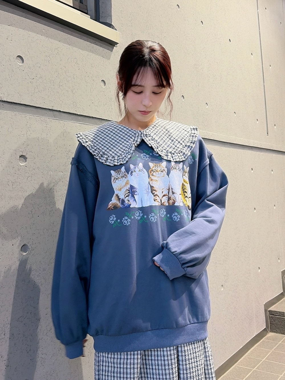 ブルー系のスウェット、ブルー系のワンピース、ブラック系のスニーカーを着用したレディースの冬コーディネートの3枚目の写真