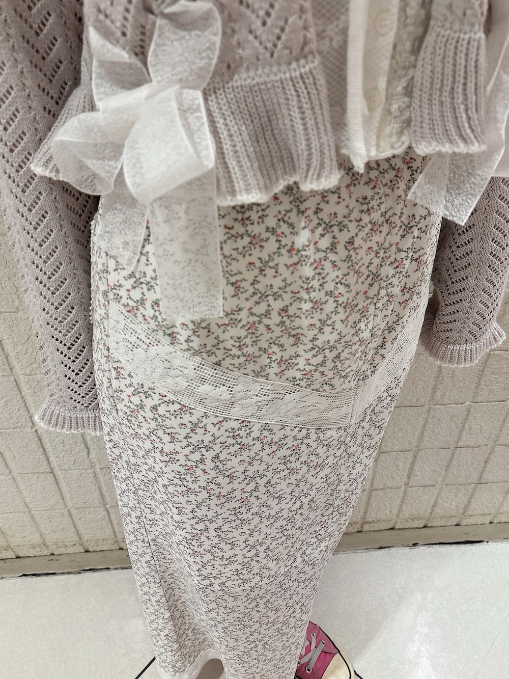 ホワイト系のカーディガン/ボレロ、グレー系のカーディガン/ボレロ、ホワイト系のスカートを着用したレディースの冬コーディネートの6枚目の写真