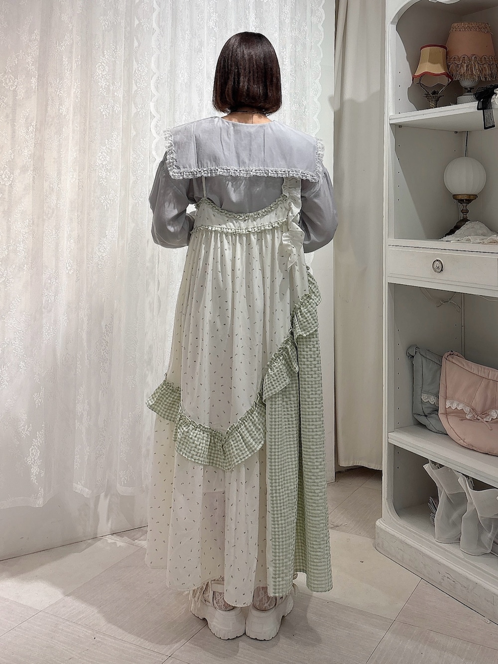 グリーン系のワンピース、ブルー系のシャツ/ブラウス、ホワイト系のサンダルを着用したレディースの春コーディネートの2枚目の写真