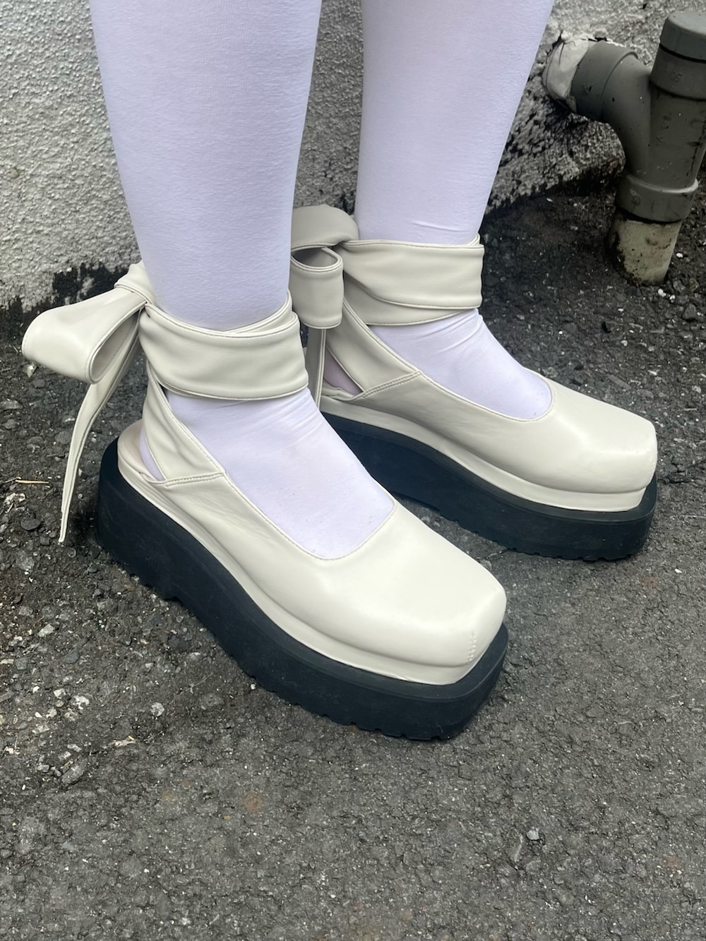 ブラック系のパンプス、ホワイト系のニット/セーター、ブルー系のテーラードジャケットを着用したレディースの春コーディネートの3枚目の写真