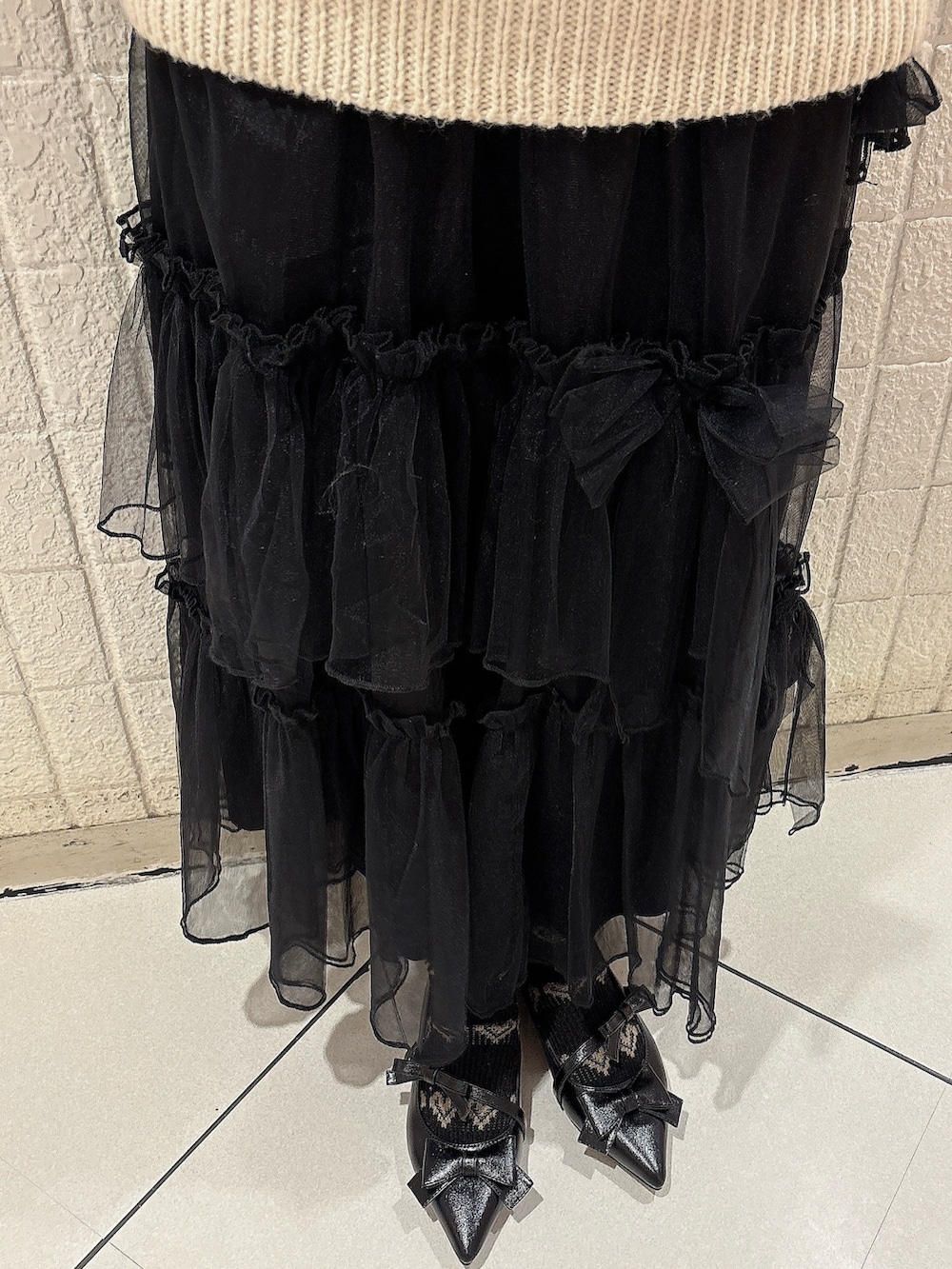 ピンク系のブルゾン、ホワイト系のニット/セーター、ブラック系のスカートを着用したレディースの冬コーディネートの8枚目の写真