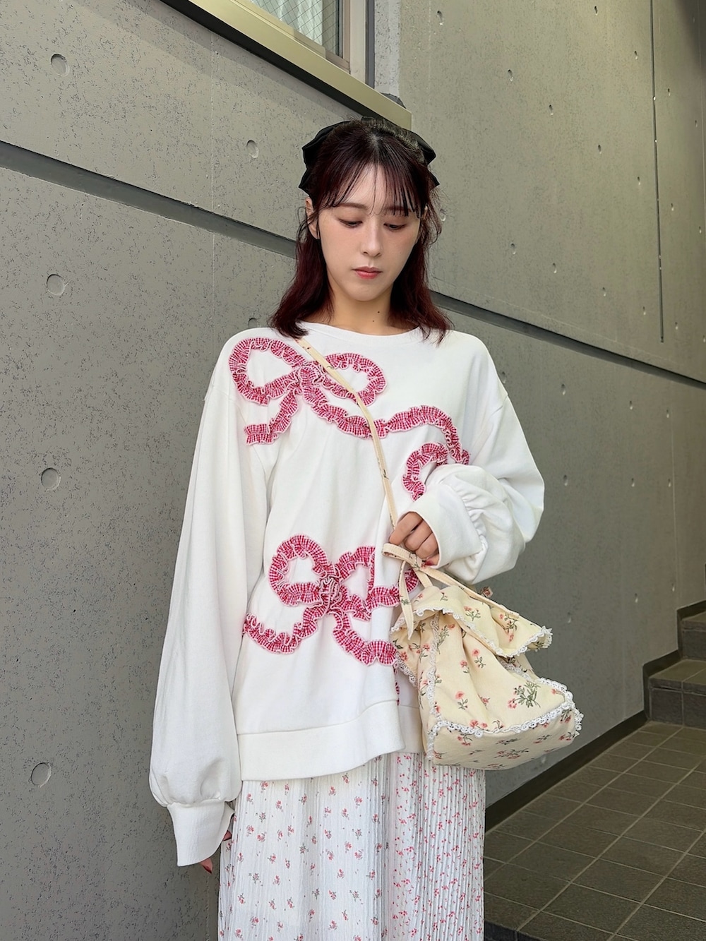 ホワイト系のスウェット、ホワイト系のショルダーバッグ、ピンク系のスカートを着用したレディースの冬コーディネートの3枚目の写真