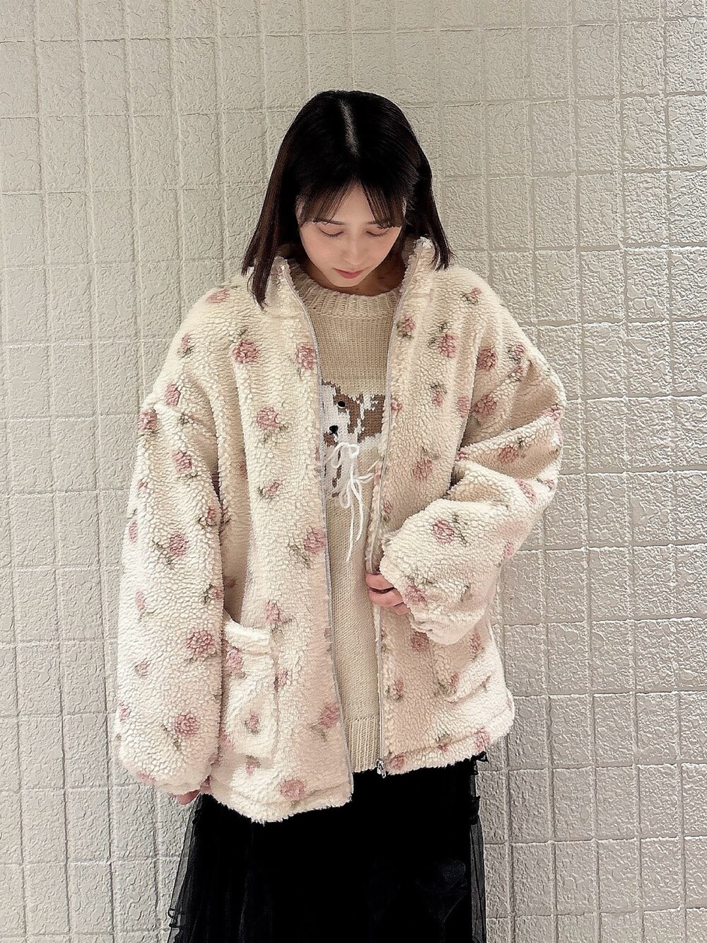 ピンク系のブルゾン、ホワイト系のニット/セーター、ブラック系のスカートを着用したレディースの冬コーディネートの3枚目の写真