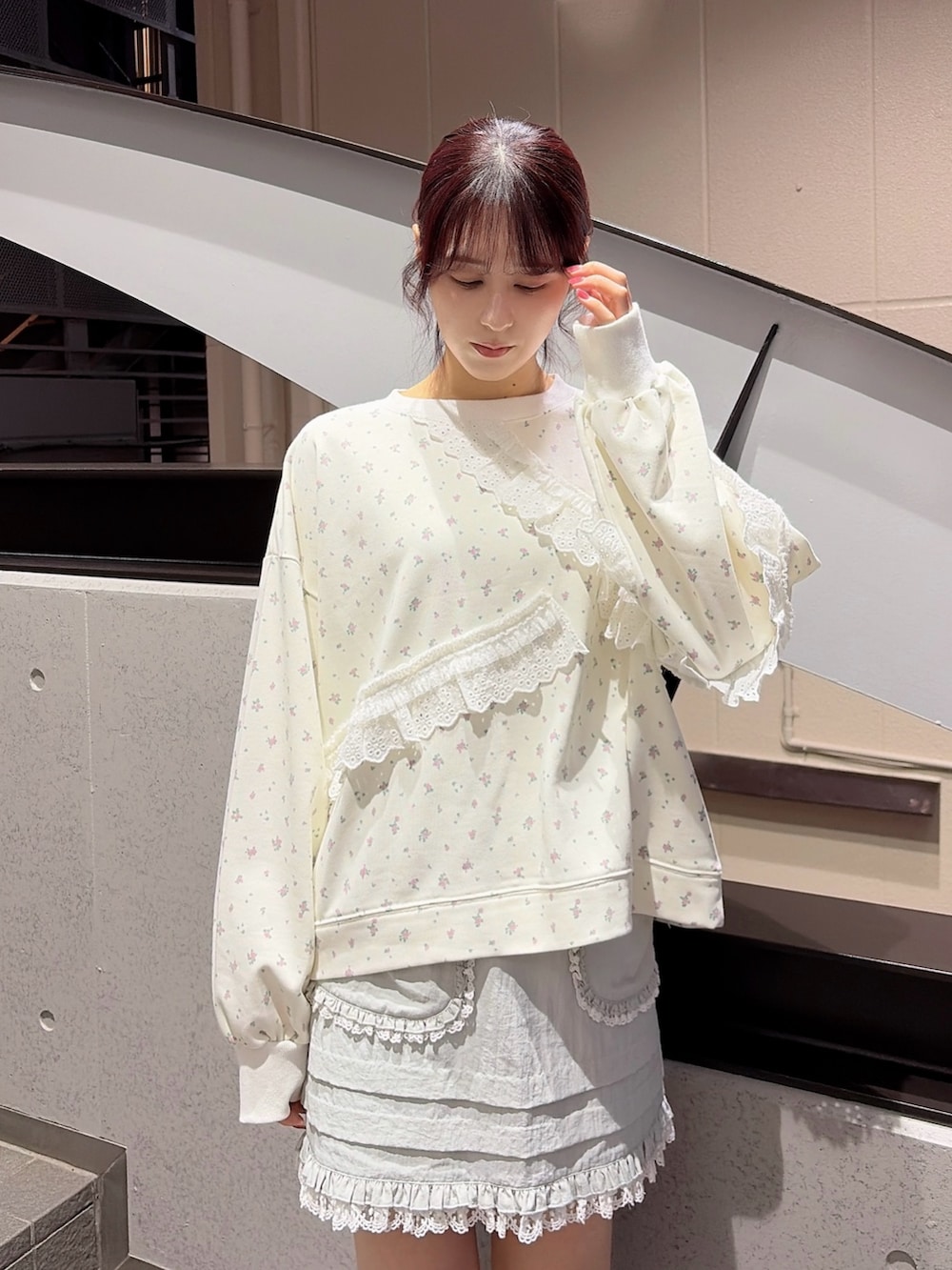 ホワイト系のスウェット、ブルー系のスカート、ブラック系のスニーカーを着用したレディースの冬コーディネートの3枚目の写真