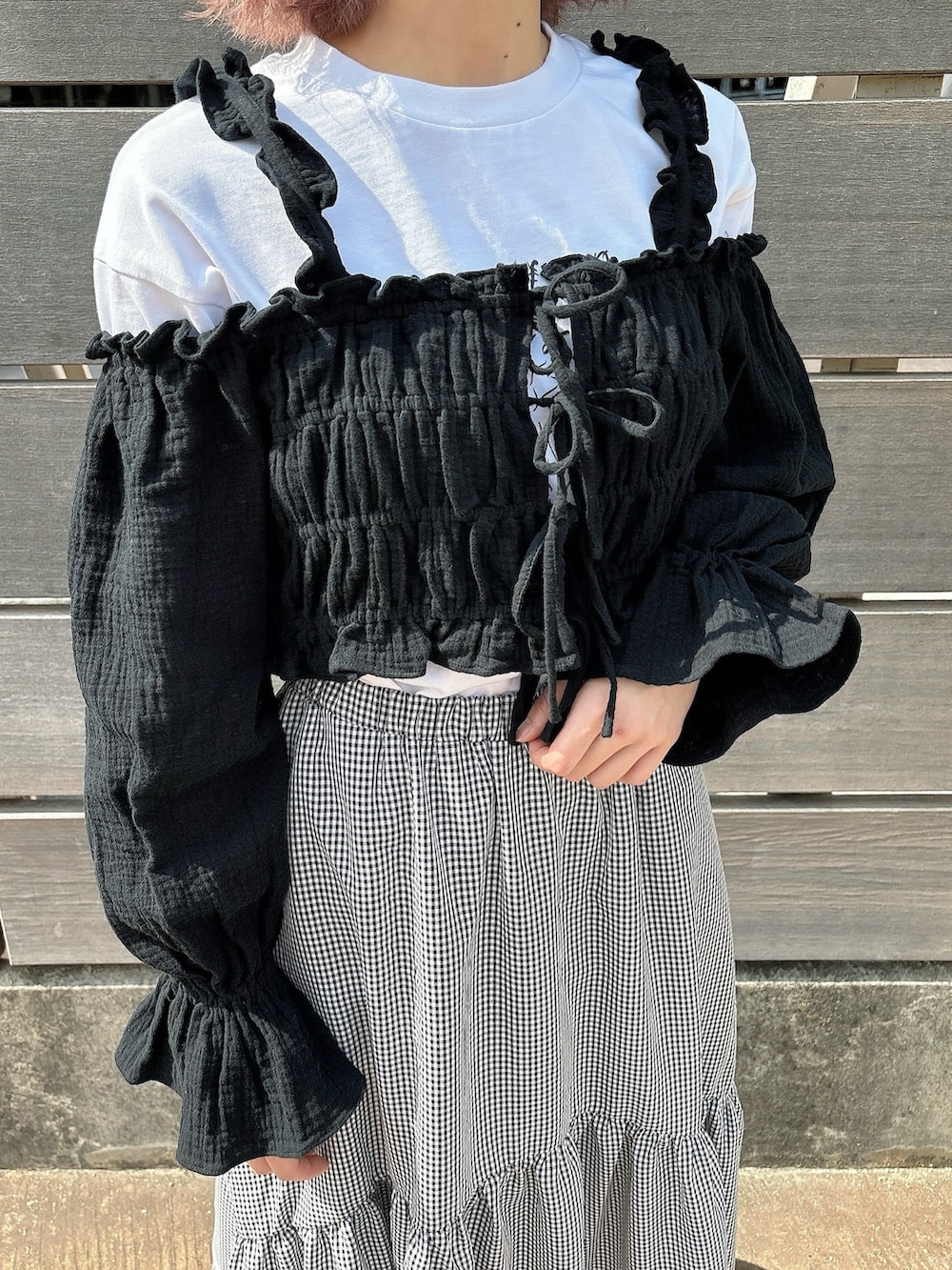 ブラック系のスカート、ホワイト系のTシャツ/カットソー、ブラック系のシャツ/ブラウスを着用したレディースの春コーディネートの6枚目の写真