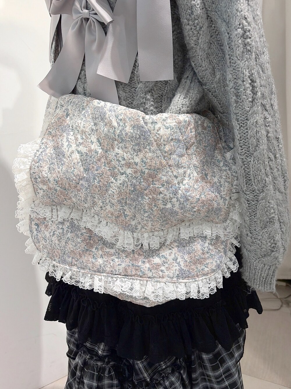 グレー系のニット/セーター、ホワイト系のショルダーバッグ、ブラック系のスカートを着用したレディースの秋コーディネートの8枚目の写真