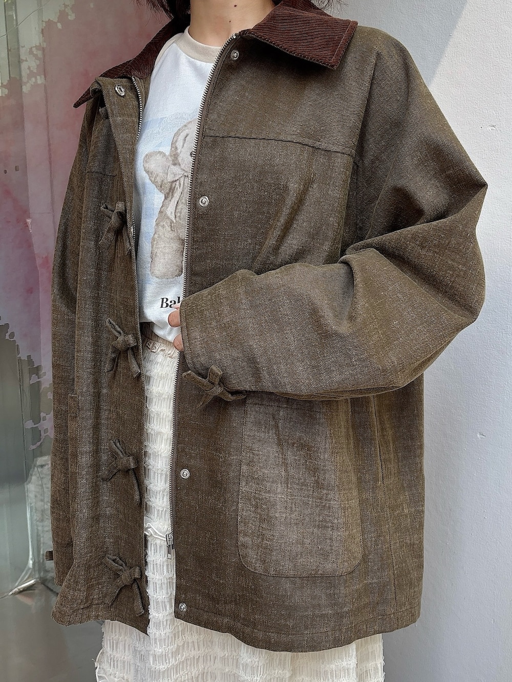 ホワイト系のスカート、ブラウン系のブルゾン、ベージュ系のTシャツ/カットソーを着用したレディースの夏コーディネートの5枚目の写真