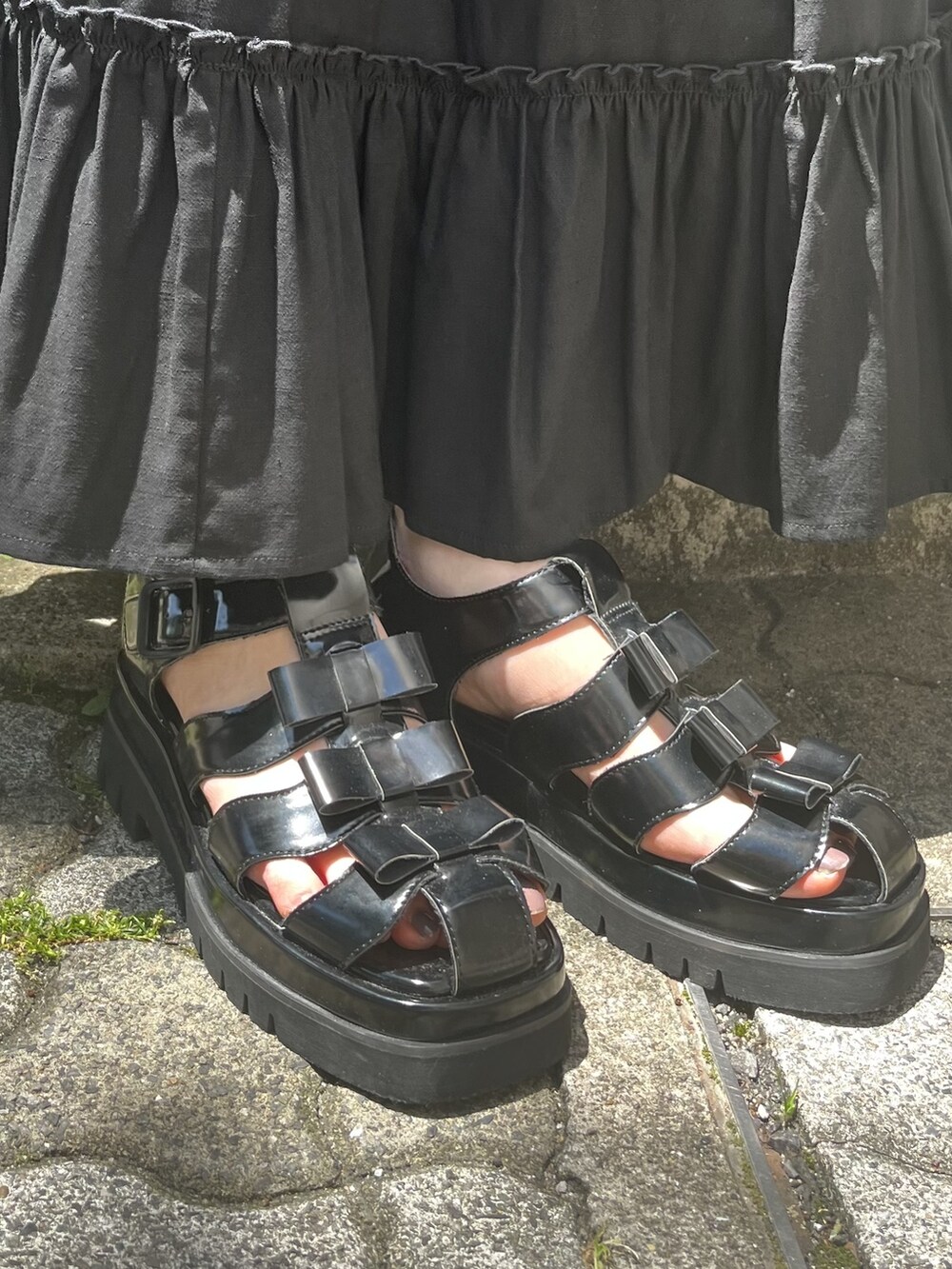 ブラック系のスカート、ブラック系のサンダル、ホワイト系のTシャツ/カットソーを着用したレディースの夏コーディネートの3枚目の写真