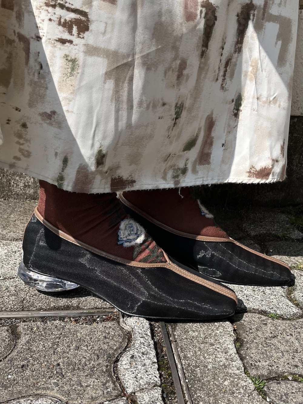 ブラウン系のスカート、ブラック系のパンプス、グリーン系のTシャツ/カットソーを着用したレディースの春コーディネートの3枚目の写真