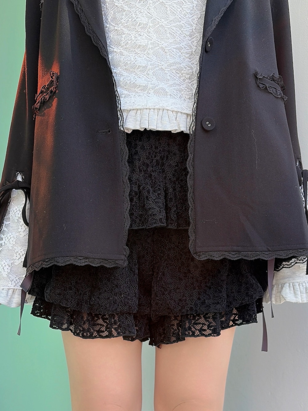 ブラック系のテーラードジャケット、グレー系のTシャツ/カットソー、ブラック系のその他パンツを着用したレディースの冬コーディネートの6枚目の写真