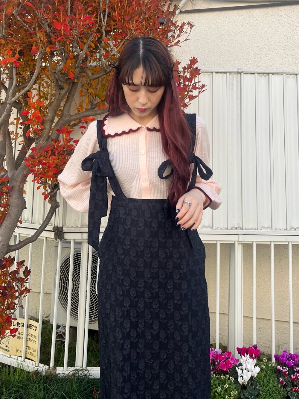 ブラック系のパンプス、ブラック系のスカート、ピンク系のニット/セーターを着用したレディースの冬コーディネートの2枚目の写真