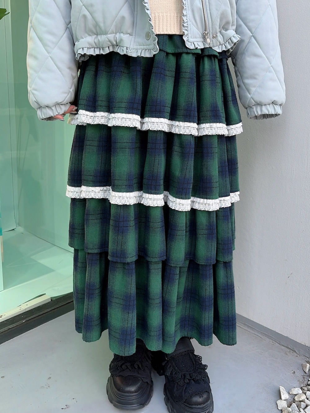 ブルー系のダウンジャケット/コート、ホワイト系のニット/セーター、グリーン系のスカートを着用したレディースの冬コーディネートの6枚目の写真