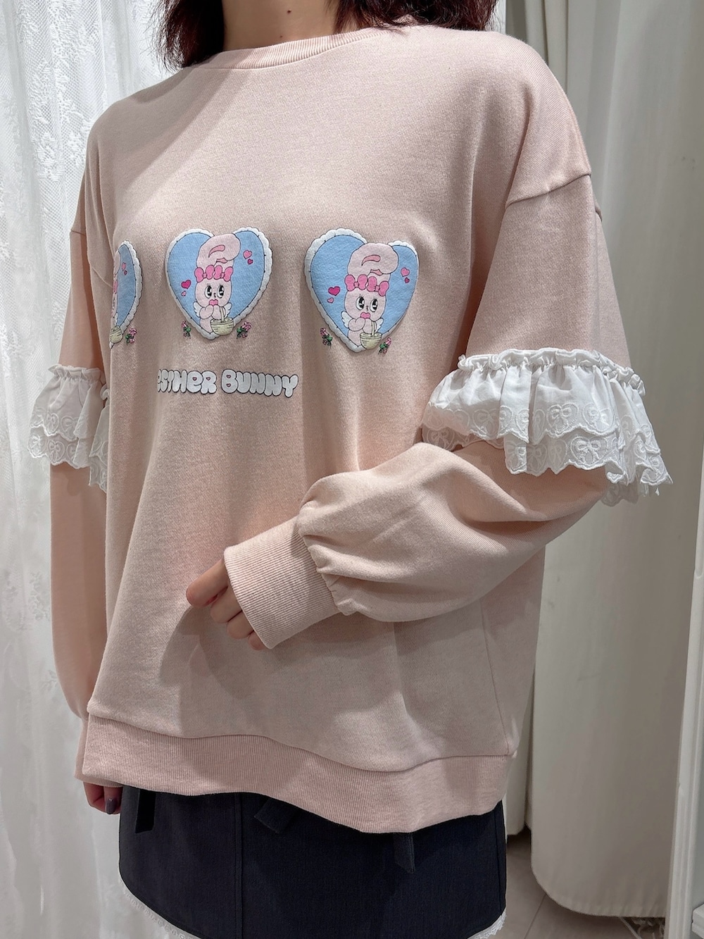 ピンク系のスウェット、グレー系のスカート、ホワイト系のスニーカーを着用したレディースの秋コーディネートの5枚目の写真