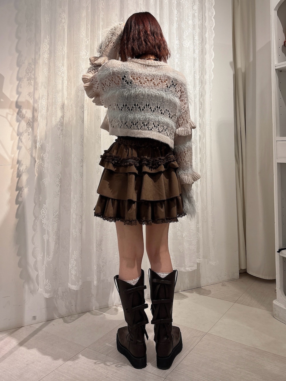 ブラウン系のスカート、ブラウン系のブーツ、グレー系のカーディガン/ボレロを着用したレディースの夏コーディネートの2枚目の写真