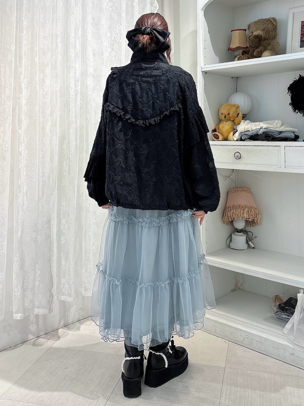 ブルー系のワンピース、ブラック系のブーツ、ブラック系のブルゾンを着用したレディースの夏コーディネートの2枚目の写真