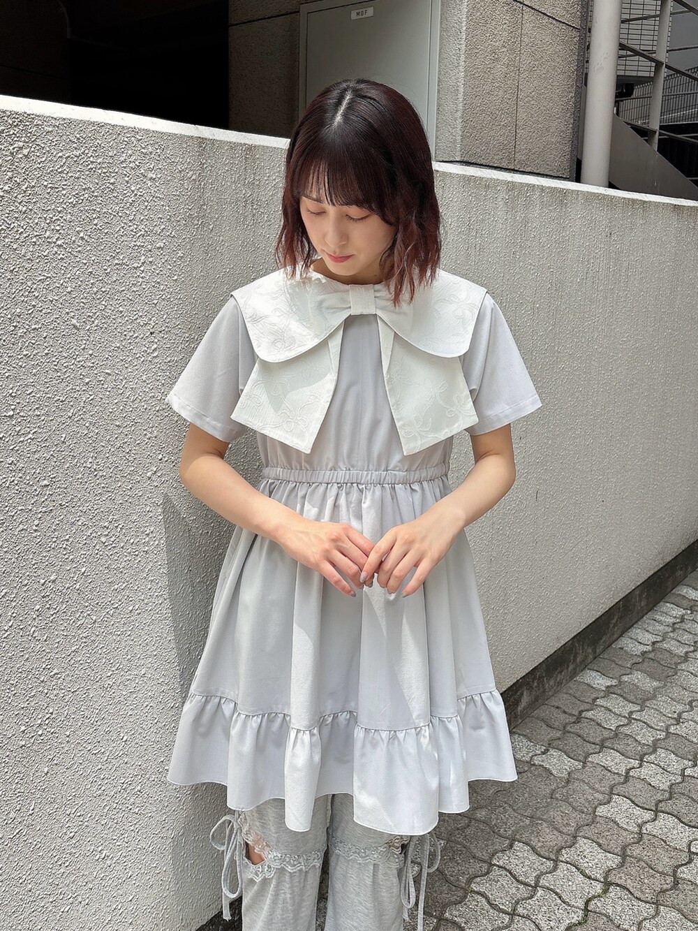 ブルー系のワンピース、グレー系のスウェットパンツ、ホワイト系のスニーカーを着用したレディースの春コーディネートの3枚目の写真