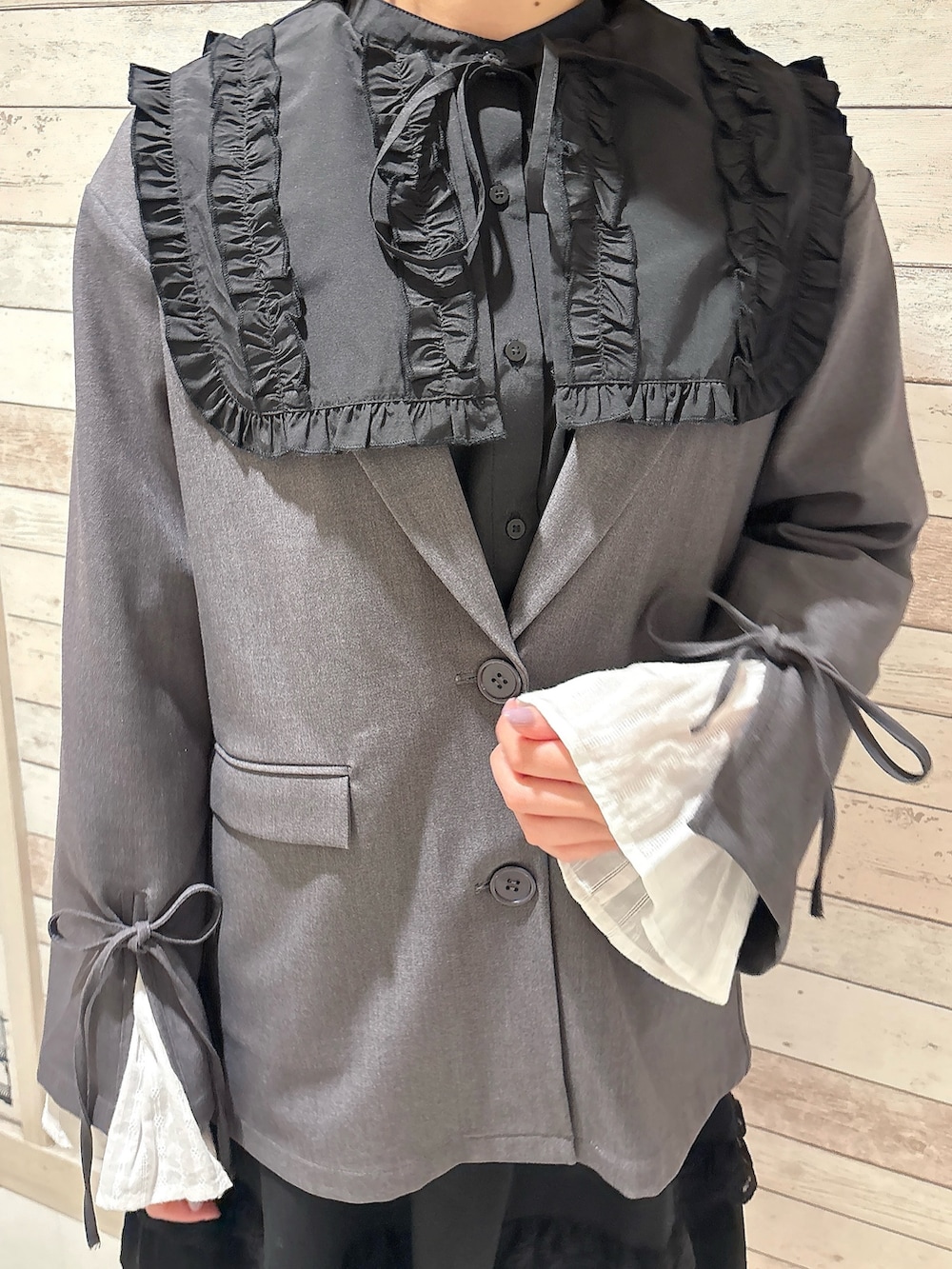 ブラック系のシャツ/ブラウス、グレー系のテーラードジャケット、ブラック系のスカートを着用したレディースの冬コーディネートの5枚目の写真