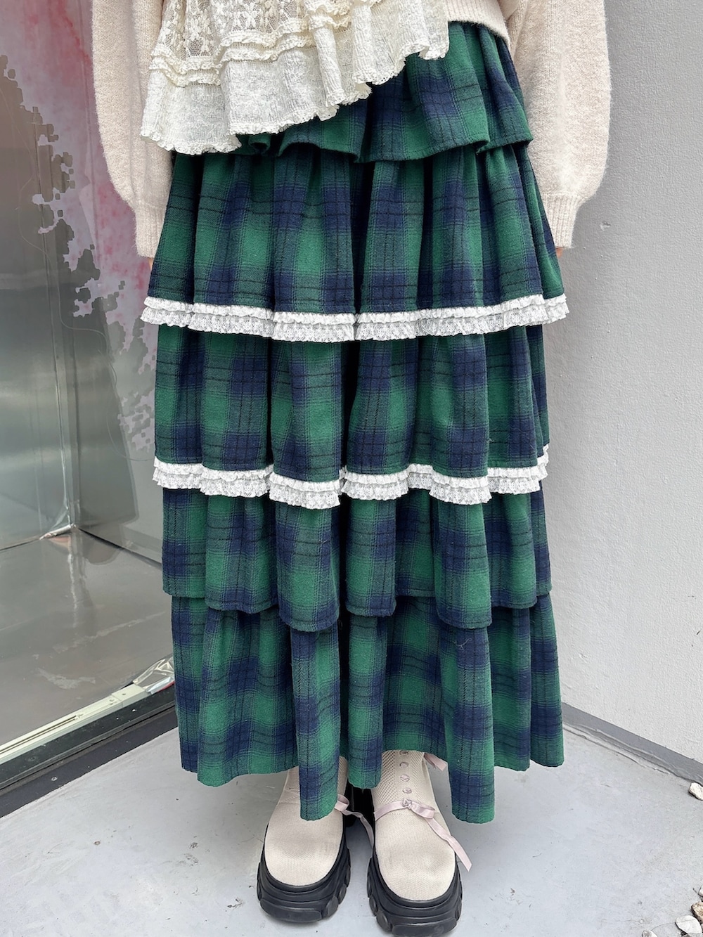 ホワイト系のニット/セーター、ホワイト系のショルダーバッグ、グリーン系のスカートを着用したレディースの秋コーディネートの6枚目の写真