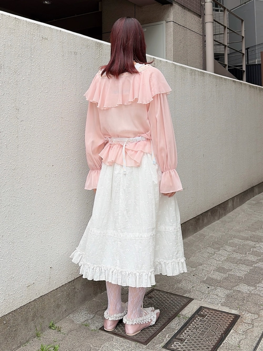 ピンク系のカーディガン/ボレロ、ホワイト系のワンピース、ブラック系のバレエシューズを着用したレディースの春コーディネートの2枚目の写真