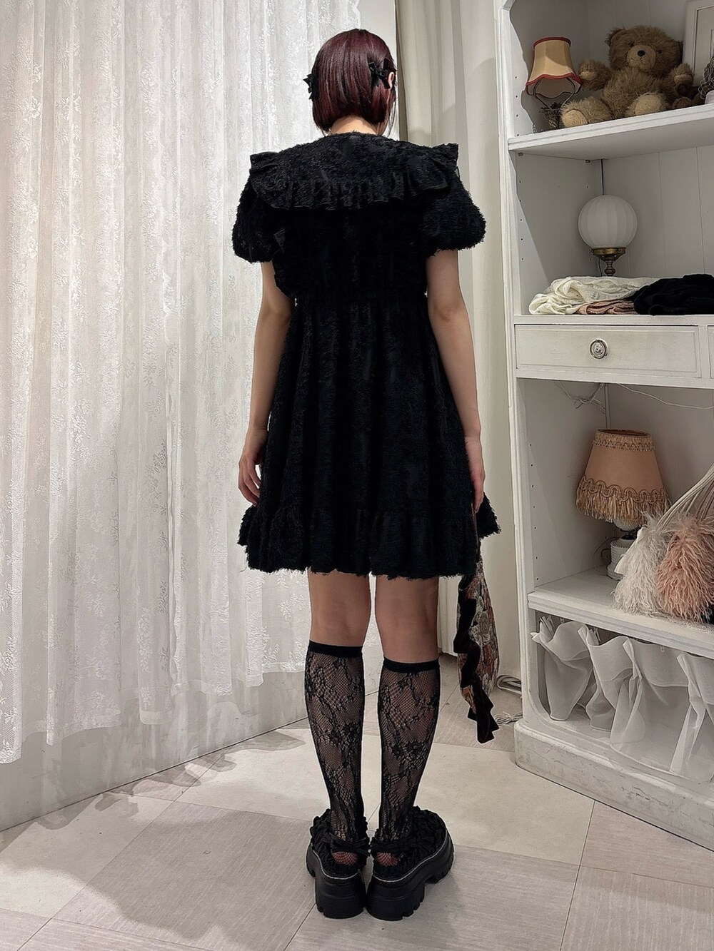 ブラック系のワンピース、ブラック系のサンダル、レッド系のハンドバッグを着用したレディースの夏コーディネートの2枚目の写真