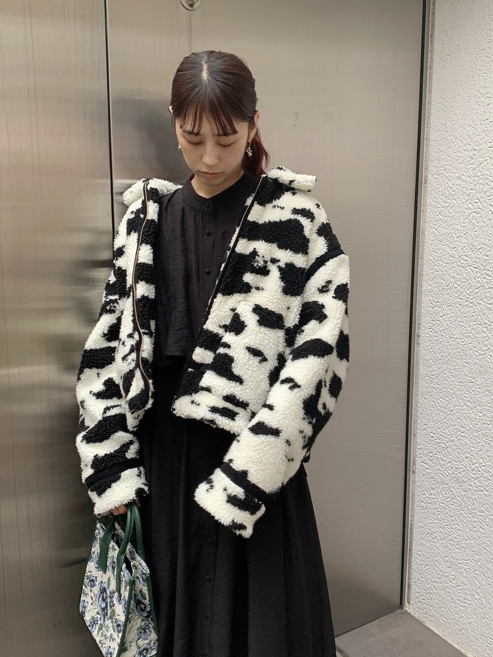 ブラック系のその他アウター、ブラック系のブーツ、ベージュ系のハンドバッグを着用したレディースの秋コーディネートの2枚目の写真