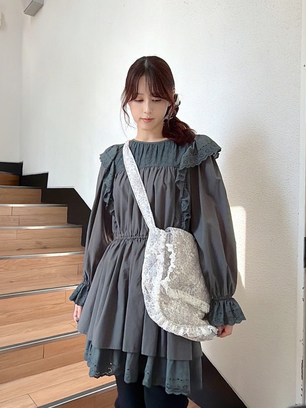 グレー系のワンピース、ホワイト系のショルダーバッグ、ブラック系のその他パンツを着用したレディースの夏コーディネートの4枚目の写真
