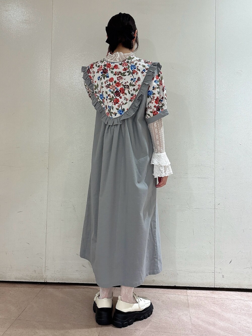 グレー系のワンピース、ホワイト系のTシャツ/カットソー、ホワイト系のローファーを着用したレディースの春コーディネートの2枚目の写真