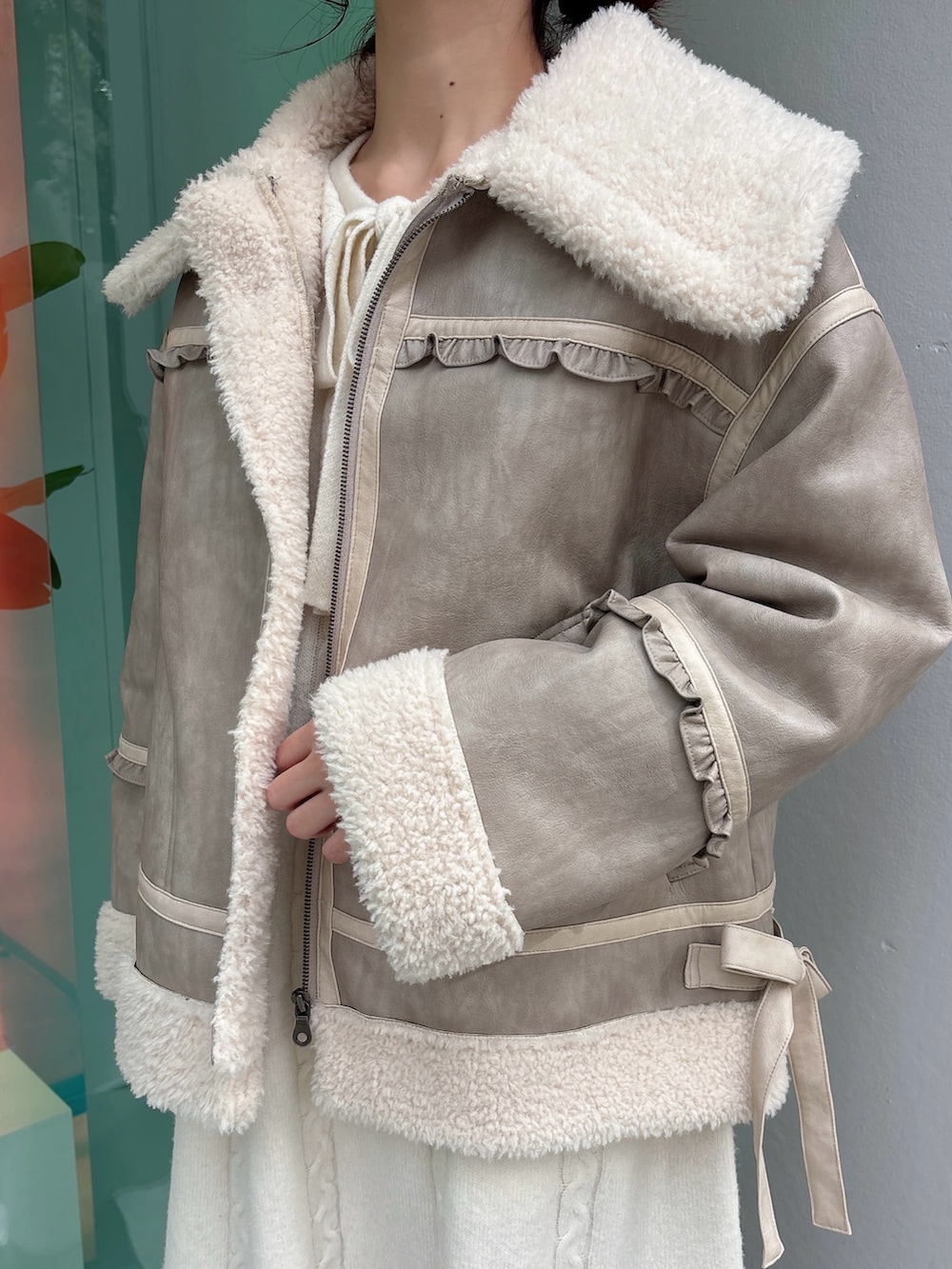 ベージュ系のムートンコート、ホワイト系のワンピース、ブラック系のブーツを着用したレディースの秋コーディネートの5枚目の写真