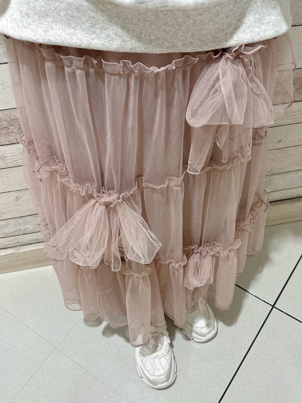 ピンク系のスカート、グレー系のスウェット、ホワイト系のスニーカーを着用したレディースの秋コーディネートの6枚目の写真