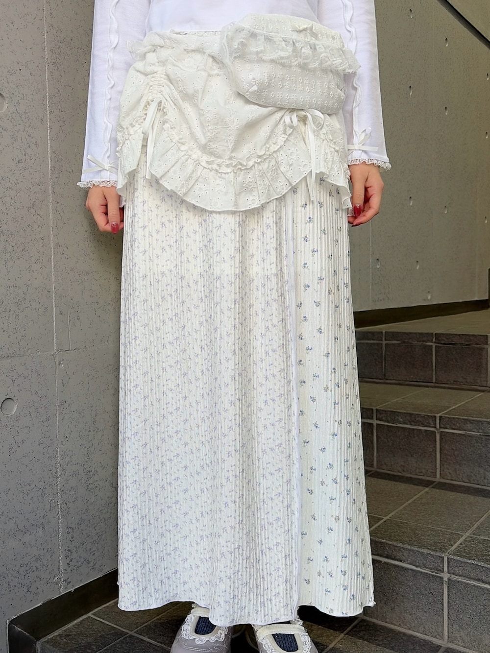 ホワイト系のポロシャツ、ホワイト系のボディバッグ/ウエストポーチ、ホワイト系のスカートを着用したレディースの冬コーディネートの7枚目の写真