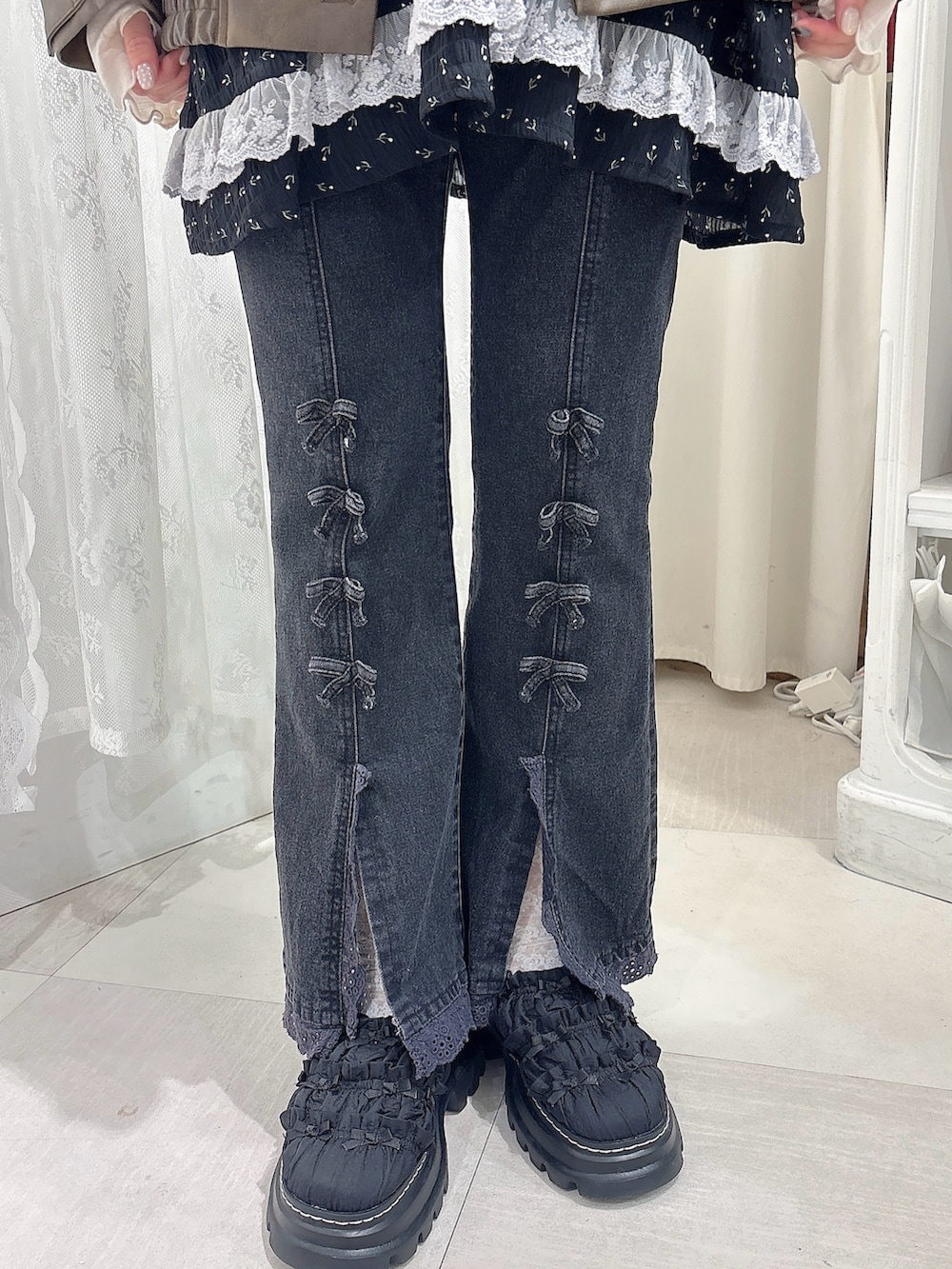 ブラック系のチュニック、ブラウン系のブルゾン、ホワイト系のTシャツ/カットソーを着用したレディースの夏コーディネートの6枚目の写真