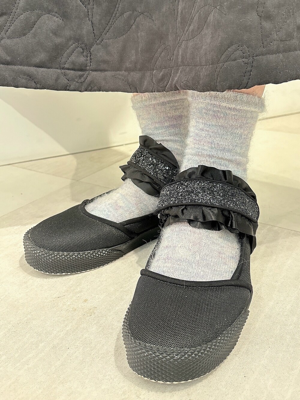 ピンク系のカーディガン/ボレロ、ブラック系のスカート、ブラック系のスニーカーを着用したレディースの冬コーディネートの6枚目の写真