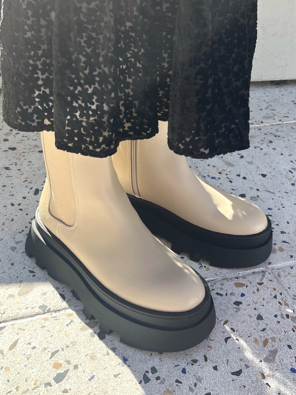 ベージュ系のブーツ、レッド系のスウェット、ブラック系のスカートを着用したレディースの冬コーディネートの5枚目の写真