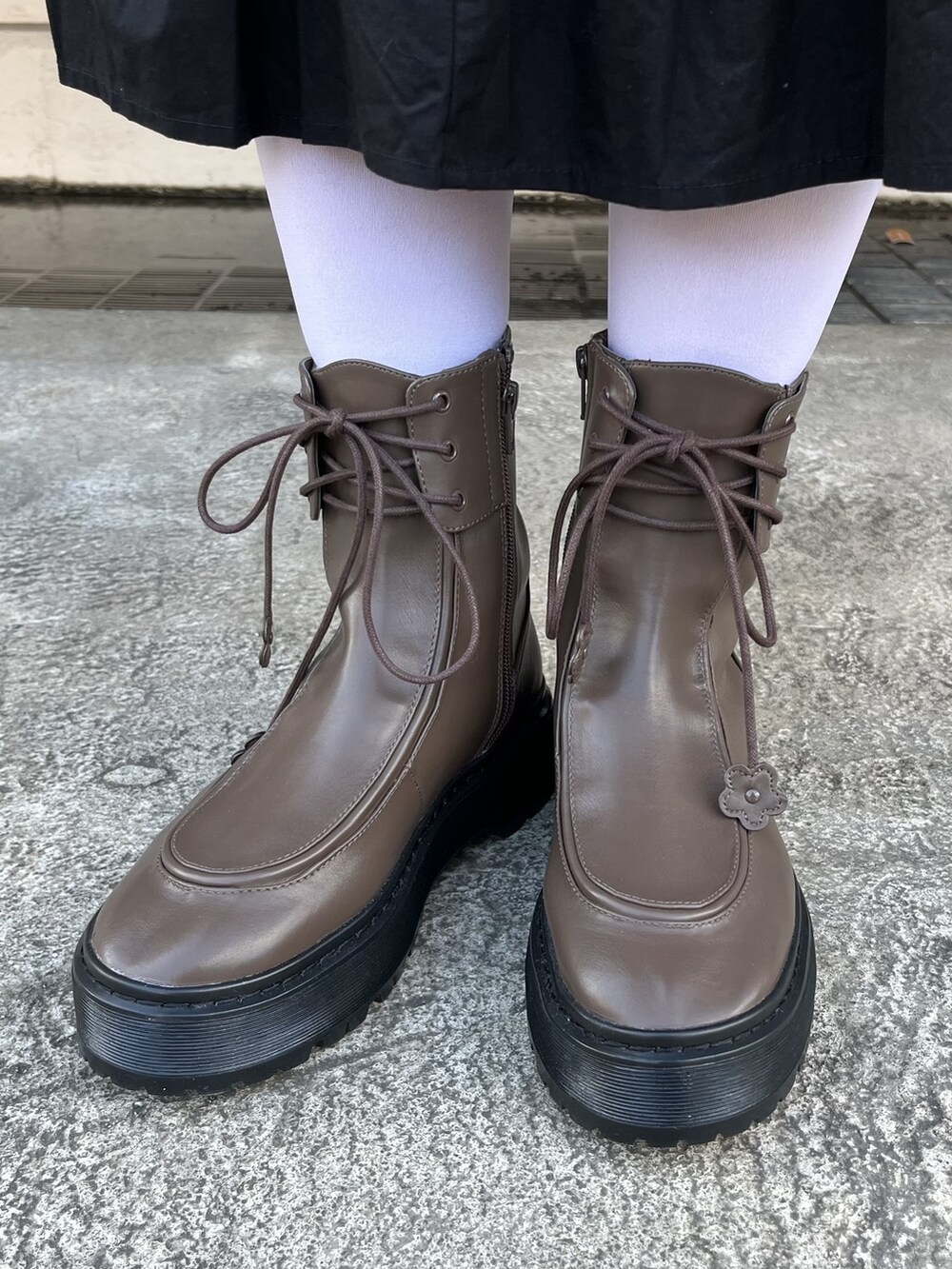 ブラック系のカーディガン/ボレロ、ブラウン系のブーツ、ブラック系のワンピースを着用したレディースの冬コーディネートの3枚目の写真