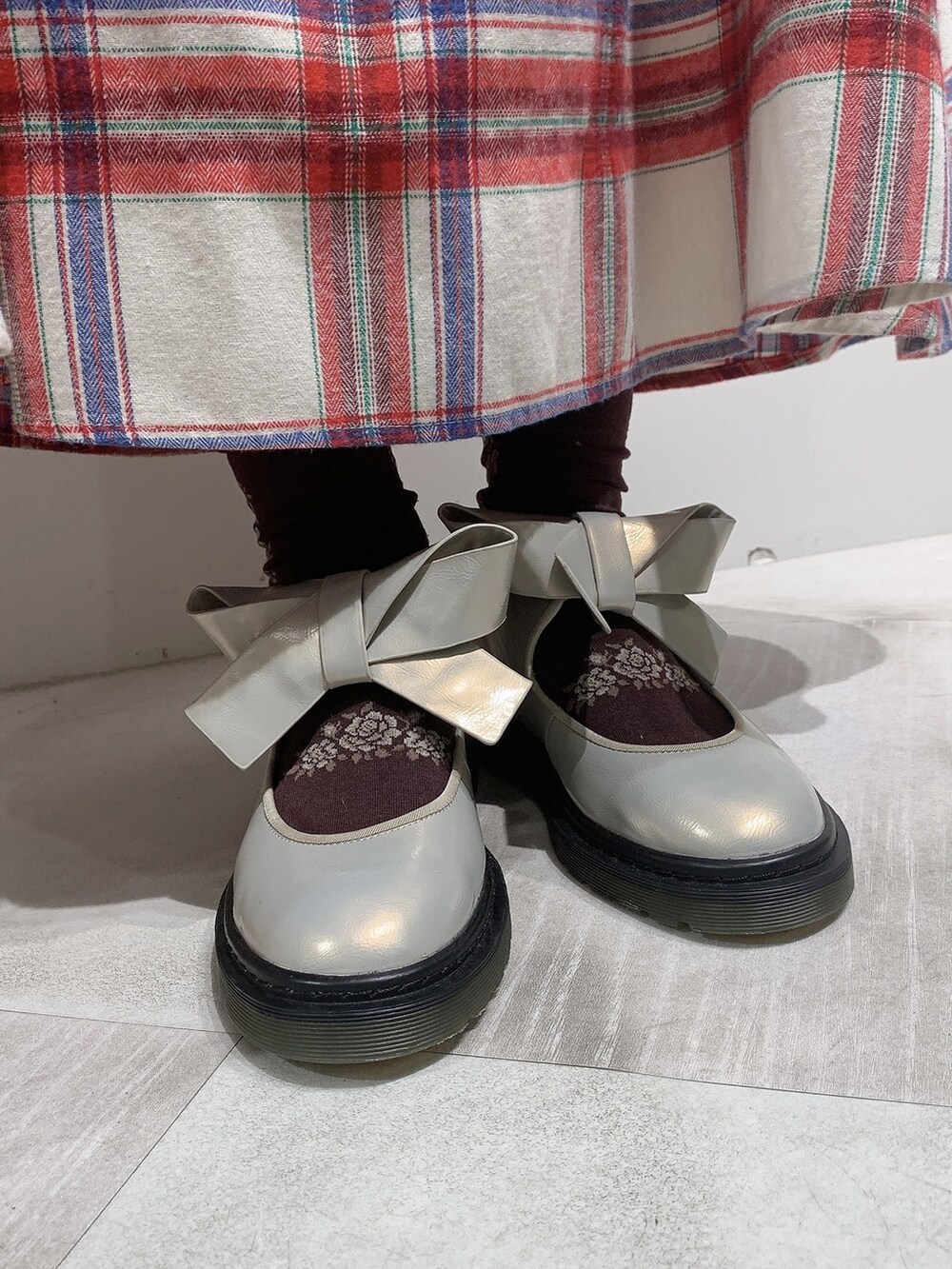 レッド系のスカート、ホワイト系のパンプス、ベージュ系のシャツ/ブラウスを着用したレディースの秋コーディネートの3枚目の写真