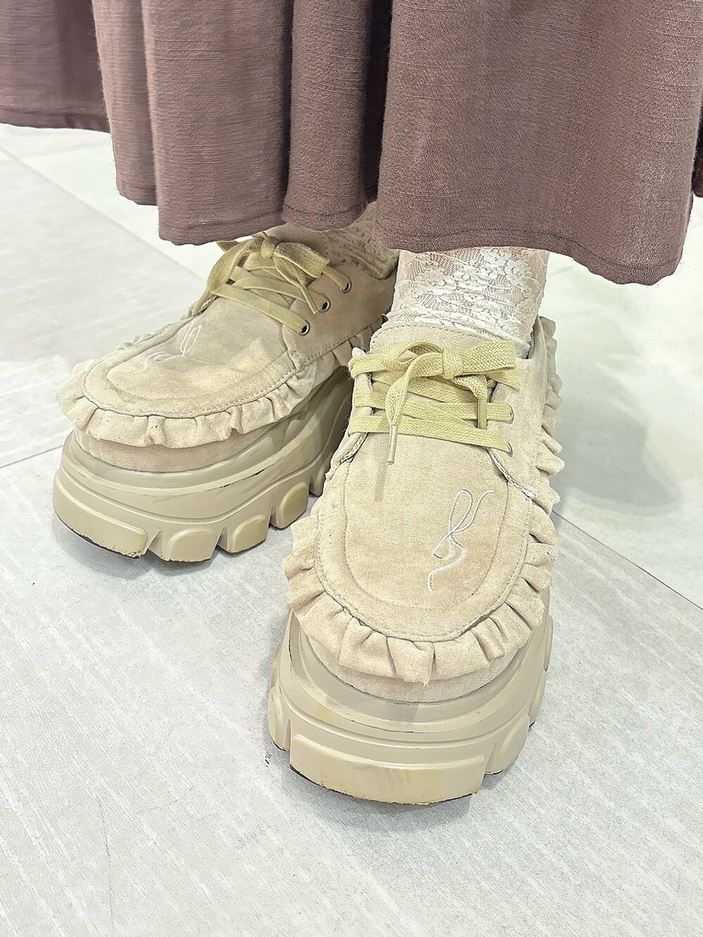 グレー系のスウェット、ブラウン系のトートバッグ、ブラウン系のスカートを着用したレディースの秋コーディネートの7枚目の写真