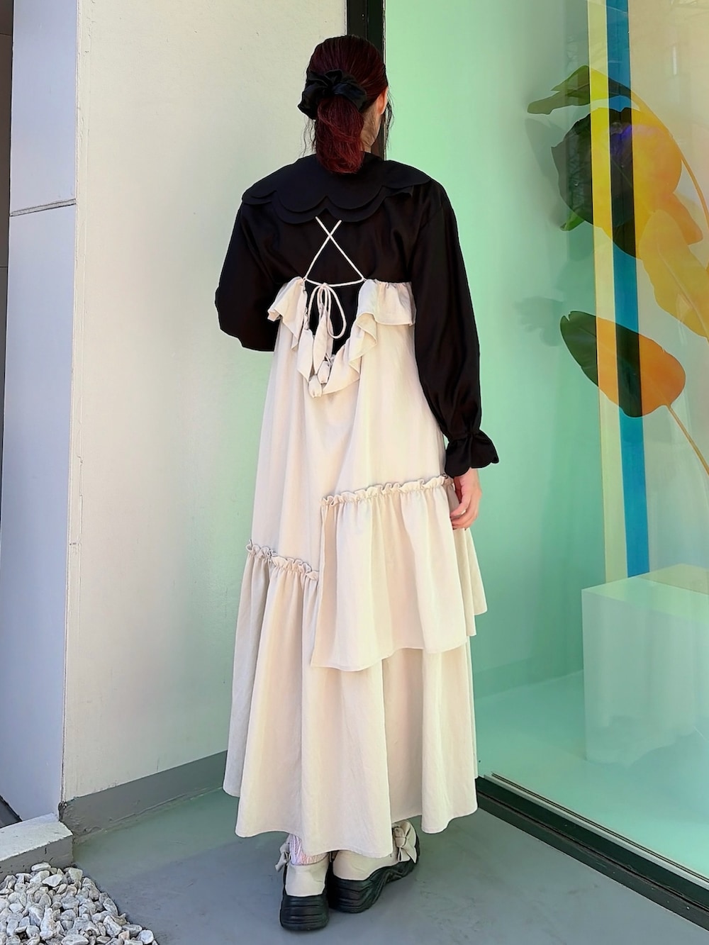 ベージュ系のワンピース、ブラック系のシャツ/ブラウス、ホワイト系のスニーカーを着用したレディースの冬コーディネートの2枚目の写真